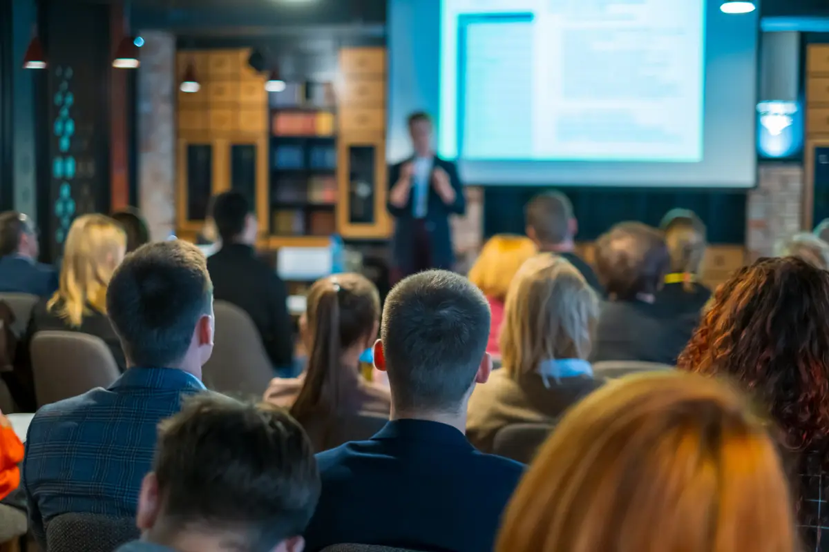 A speaker presenting to an audience of professionals during a training session